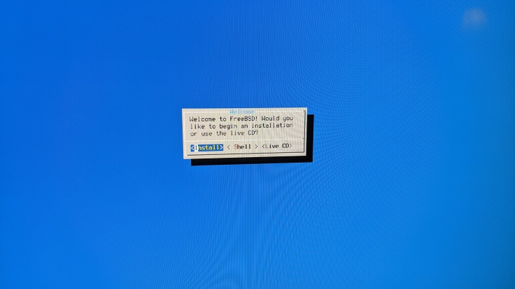 Picture of the FreeBSD installer's text-based UI with blue background, asking if you want to install, run a shell, or launch the Live CD