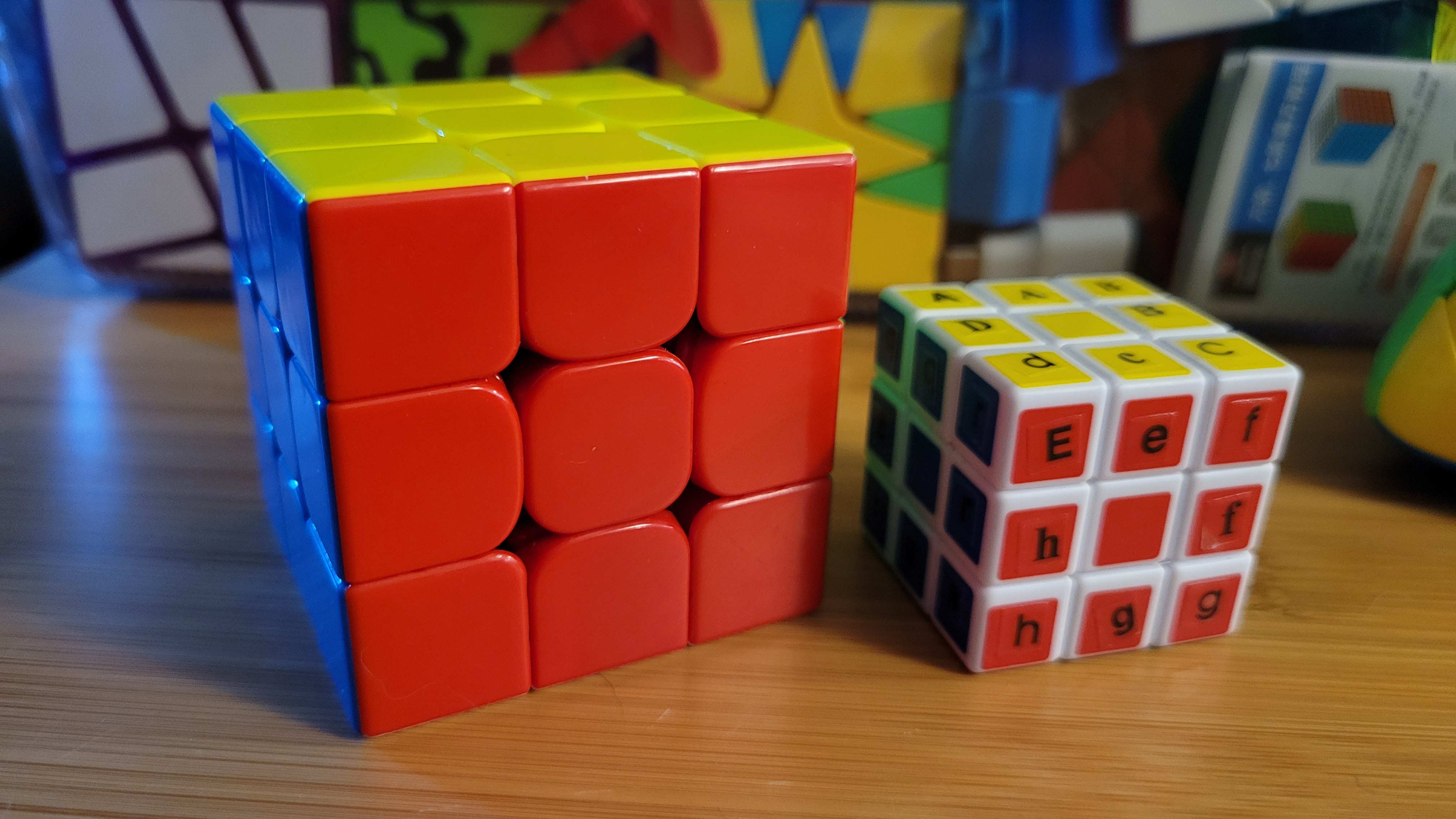 Photo of two solved cubes, one with letter stickers on each piece