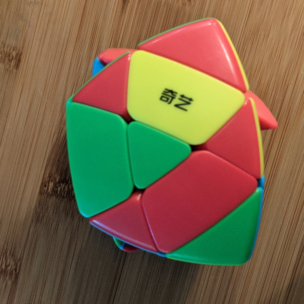 Photo of a scrambled pyramorphix twisty puzzle showing three red triangle sides of center pieces